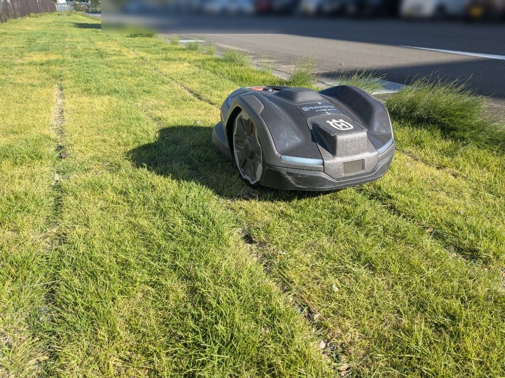 縁石沿いの芝生を進むロボット芝刈機